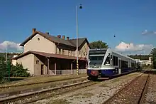 La photo montre une rame bleue et grise à quai dans une gare.