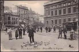 Charmeur de pigeons sur la place Saint-Lambert en 1918, avec une partie du square Notger en arrière-plan.