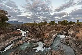 Cascades de Li Phi (chutes de Khone) au lever du soleil avec des nuages colorés.