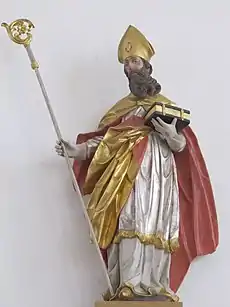 Statue polychrome d'un évêque tenant sa crosse et une bible.