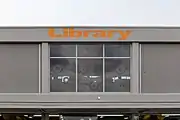 Bâtiment vitré sur la façade duquel est écrit « Library ».