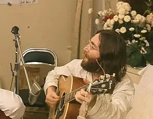 Lennon, les cheveux longs, enregistrant Give Peace a Chance en 1969