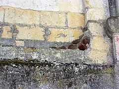 Photographie en couleurs de vases en terre cuite encastrés dans un mur.