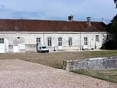 Photographie en couleurs d'un long corps de bâtiment sans étage.