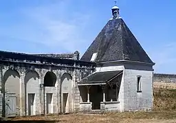 Photographie en couleurs d'un petit bâtiment carré coiffé en pyramide.