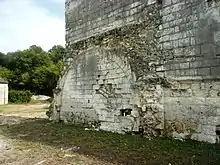 Photographie en couleurs d'un mur sur lequel est plaqué un grand arc brisé.