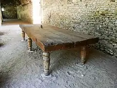 Photographie en couleurs d'une grande table en bois massif.