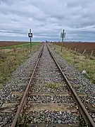 Vue de la ligne depuis le PN33, sur sa section encore exploitée entre Pithiviers et Engenville.