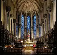 Photographie en couleurs de la chapelle vue de face et de ses quatre travées du sol à la clé de voute avec au centre l'autel.