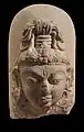 Linga à visage divin : le troisième œil sur le front symbolise l'omniscience de Shiva. VIIIe – IXe siècle. Calcaire, H. 25 cm. Inde du Nord