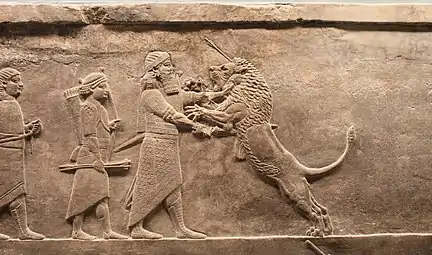 Le roi, suivi de serviteurs, poignarde un lion qui se jette sur lui.