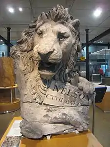 Partie d'un monument conçu par B. West au Greenwich hospital représentant la mort de l'amiral Nelson. Le lion britannique tient un rouleau rappelant les 122 batailles de Nelson.