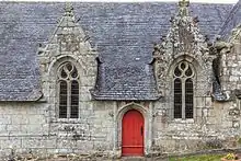 Porte rouge encadrée de deux fenêtres. Nombreuses crossettes et chimères. À droite, on voit l'amorce du croisillon sud.