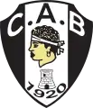 Blason noir et blanc avec une tête de Maure, symbole de la Corse. En dessous figurent une tour et la date 1920.