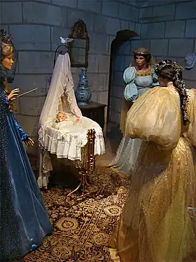 Les fées marraines se penchent sur le berceau de la princesse.