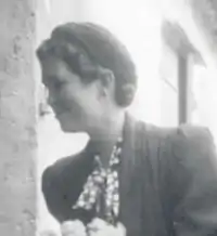 Photo noir et blanc d'une jeune femme de profil, souriante, se penchant
