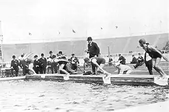 Photographie noir et blanc, quatre hommes plongent dans un bassin