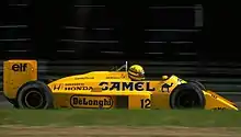 Photographie en couleur d'une Formule 1 jaune or, vue de profil droit, sur une piste.