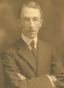 Photographie noir et blanc d'un homme en habit cravate.