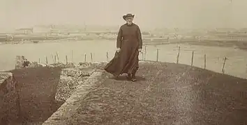 Louis Duchesne marchant sur le fort de la Cité d'Aleth à Saint-Servan, avec la cité corsaire de Saint-Malo en arrière-plan.