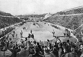 Photographie noir et blanc montrant un stade rempli de spectateurs.