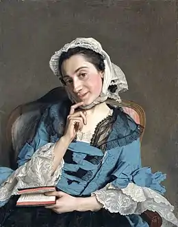 Portrait d'une femme assise, la tête penchée, tenant d'une main un livre, l'autre sur le menton, l'expression coquette.