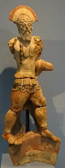 Statuette en terre cuite d'un soldat marchant et portant un casque à crête et une armure.
