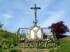 La croix Saint-Justin avec monument aux morts ; à la sortie sud du bourg.