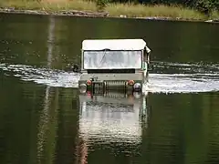 "Vue de face d’un véhicule sur un lac, l’eau arrive presque jusqu’au capot avant"