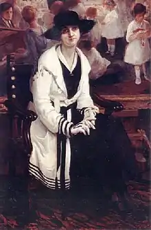 Tableau représentant Georgina Albuquerque. Elle est assise au premier plan dans un salon fréquenté : elle porte une robe et un chapeau noirs avec un pardessus blanc. Elle regarde directement le spectateur, les mains gantées jointes sur les genoux.