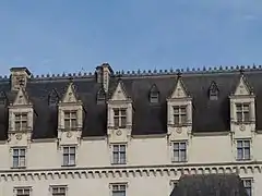 Photographie en couleurs de grandes fenêtres d'un château.