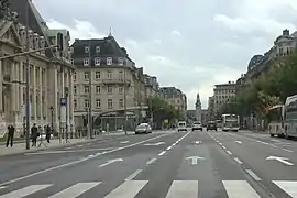 Au premier-plan, l'avenue de la Liberté en direction du sud. À l'arrière-plan, on peut apercevoir la gare centrale.