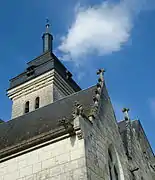 Vue en contre-plongée d'une partie de la tour et du clocher, et d'un pan de toit de la nef.
