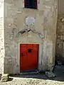 Porte de la tour d'escalier avec le blason.