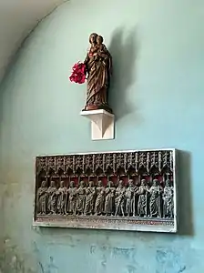 Le retable « Le Christ et les Apôtres » et la Vierge à l'Enfant en bois visibles dans la chapelle des Fonts baptismaux.