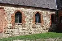 Mur de la nef en pierre calcaire et en brique.