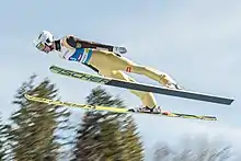 Un homme volant comme un oiseau ses skis comme des ailes.