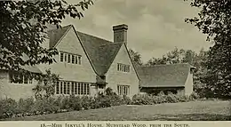 Photo en noir et blanc d'une grande maison entourée d'un jardin