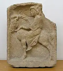 La sculpture représente un petit cheval trapu vu de profil sur lequel est montée une jeune femme à la longue robe, sa main gauche tenant les rênes et la main droite portée vers l’avant.