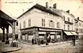 Le café du centre à côté de la halle ; l'ancien magasin de meubles à droite correspond à l'actuel Caviste.