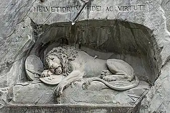 Lion de Lucerne (1819), Lucerne. L'inscription Pour la loyauté et le courage de la Suisse, la fleur de lys, la flèche brisée dans le corps du roi-lion, commémorent les Gardes suisses morts aux Tuileries pour leur fidélité à Louis XVI.