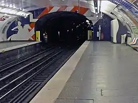 Les quais avec leur décoration thématique sur le drapeau des États-Unis avec, en arrière-plan, la station Poissonnière aperçue au bout du tunnel.