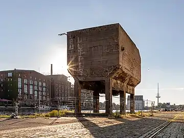 Un énorme dépôt ou container en béton sur pilotis.