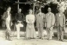 Photographie en noir et blanc d'une réunion de six personnes.