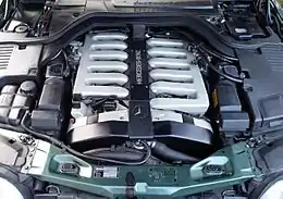 Photo du moteur V12 sous le capot d'une Mercedes-Benz 600 SEL, avec deux collecteurs d'admission à 6 branches.