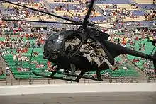 Un MH-6 Little Bird du 160th SOAR faisant une démonstration d'infiltration avec des hommes du 5th SFG(A) en 2008 au Kansas Speedway.