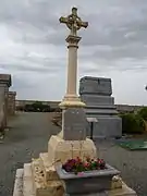 Monument aux morts, situé dans le cimetière du Courtil Frenoy, avec en arrière-plan la tombe de la famille Duquesnel comptant plusieurs personnalités de la commune.