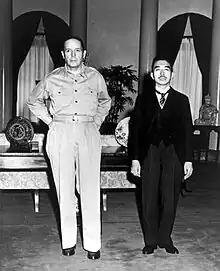 MacArthur en uniforme à côté d'un Asiatique plus petit et portant un costume.