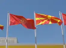 Photographie montrant l'ancien drapeau et le nouveau disposés ensemble au centre sportif Boris Trajkovski