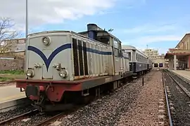 Locomotive LDe livrée du compartiment de Macomer, devant des voitures V2D.